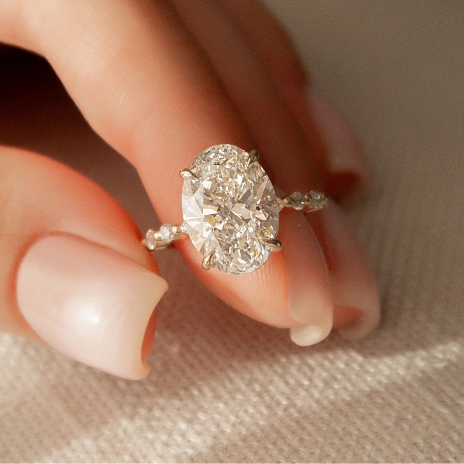 Common :: 4.90TCW oval lab grown diamond hidden halo engagement ring with round and marquise accents.