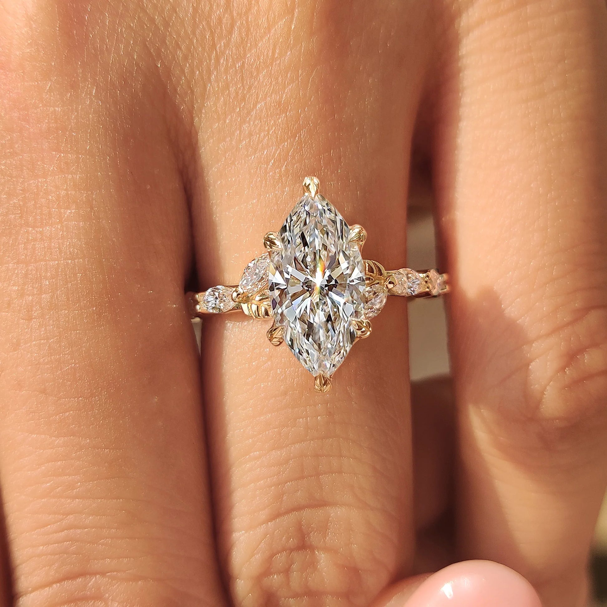 Common :: Luxury bridal ring with a marquise lab grown diamond center stone and sparkling botanical side diamonds.