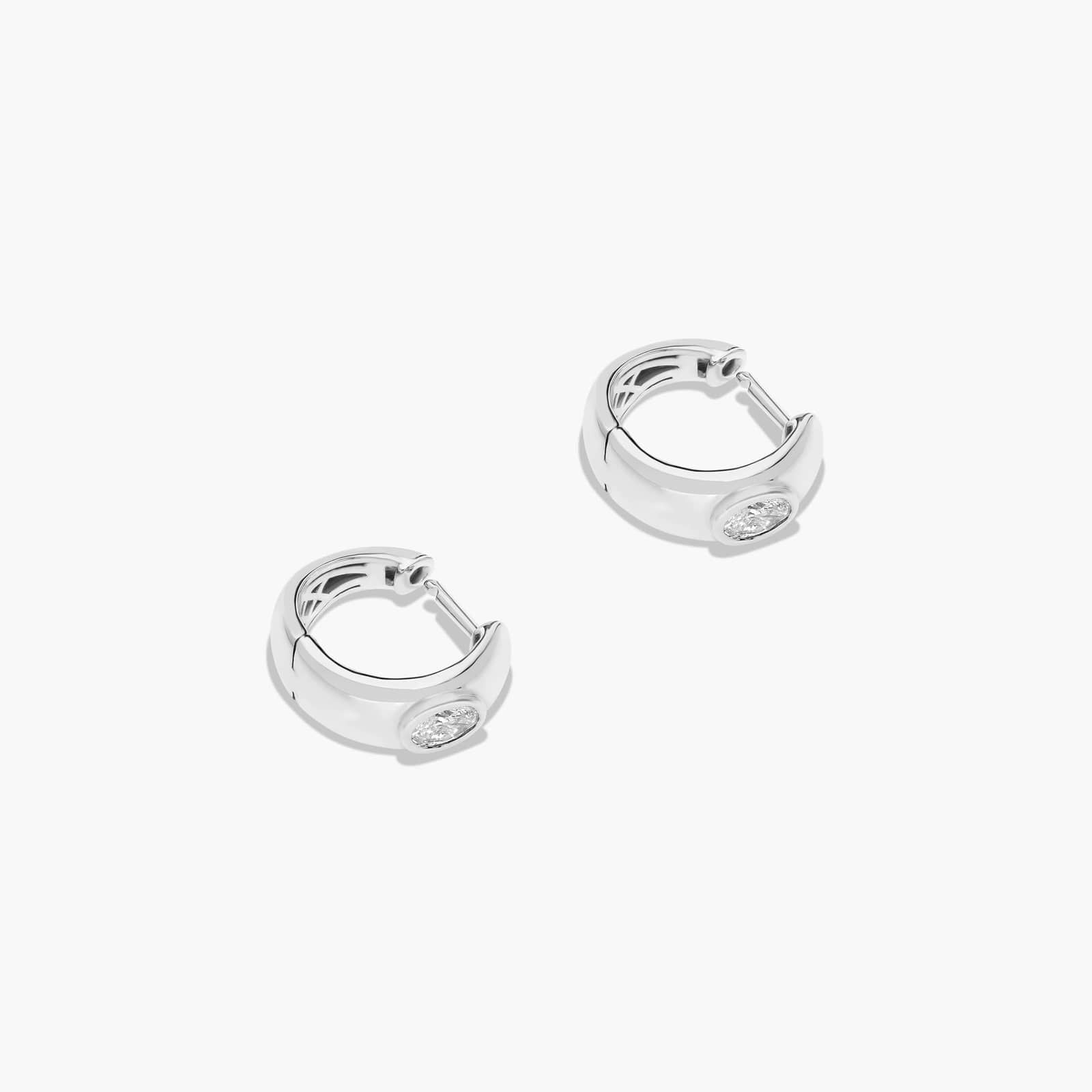 White :: delicate oval lab grown diamond huggie earrings bezel design white gold subtle everyday luxury