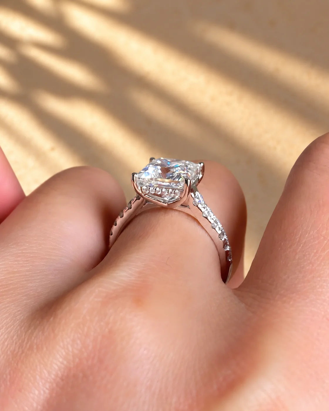 Common :: Close-up of a princess lab diamond engagement ring with hidden halo detailing.