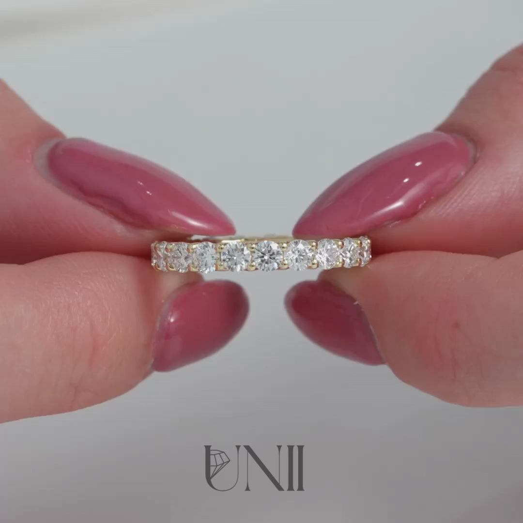 Yellow :: Classic 2ct round lab grown diamond eternity ring in yellow gold featuring IGI certified diamonds. A timeless full band with trellis setting that enhances brilliance and creates an elegant woven side profile.