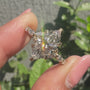 Common :: Close-up of a marquise cut lab grown diamond ring showcasing botanical leaf details and sparkling side diamonds.